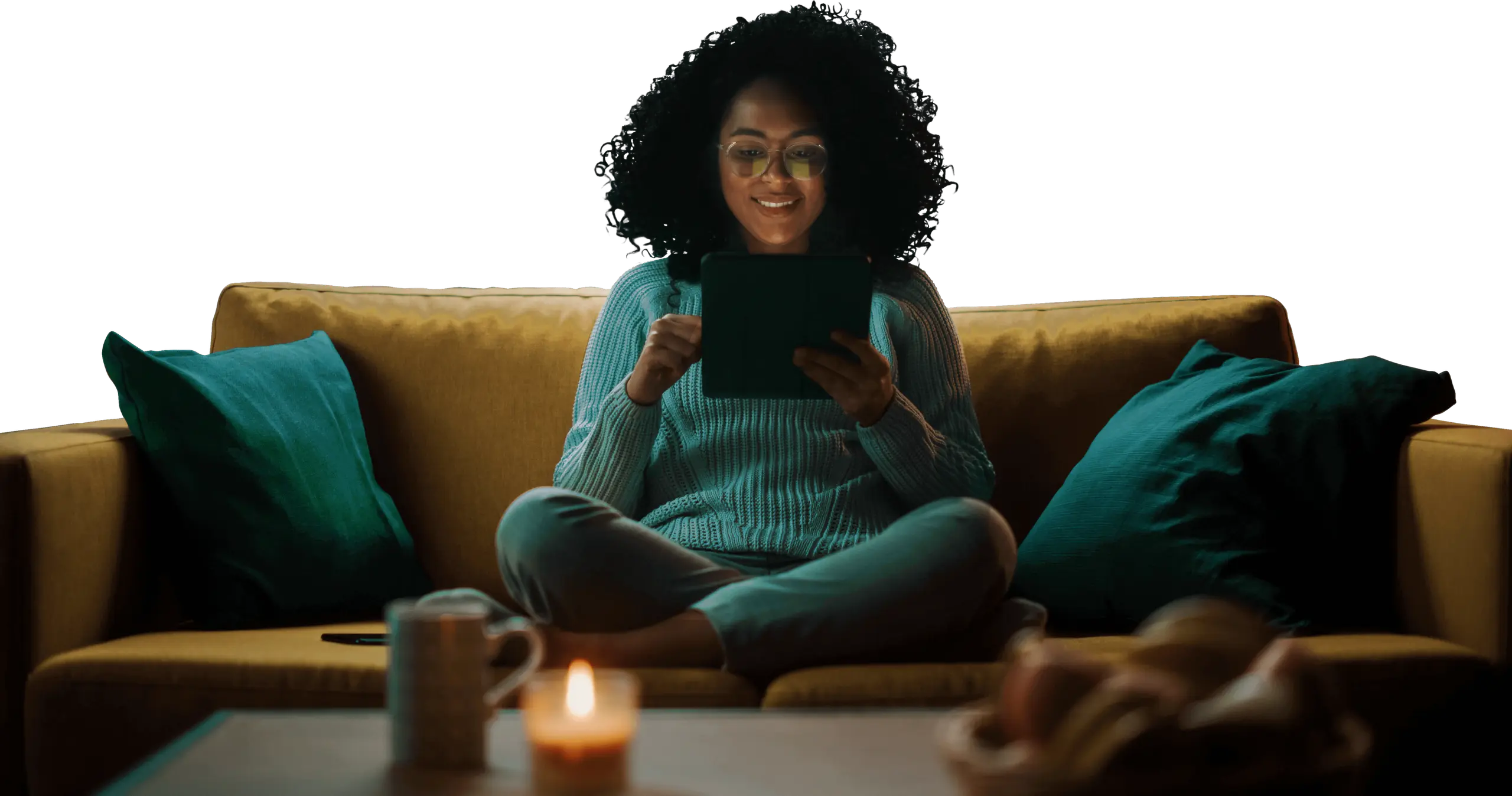 A smiling woman with glasses and curly hair looking down at her tablet